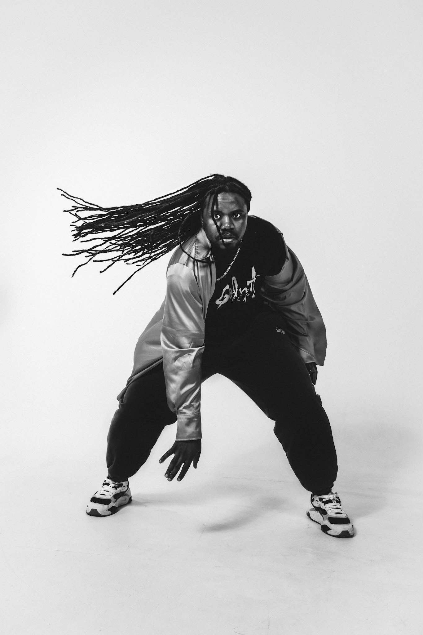 Black-and-white movement portrait of dancer and multidisciplinary artist Bruce Karim.